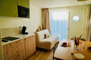 a kitchen and living room with a table and a chair at Le Bel Iris - Accès direct plage in Châtelaillon-Plage +3 photos