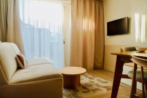 a living room with a couch and a table and a television at Le Bel Iris - Accès direct plage in Châtelaillon-Plage
