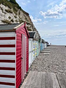 a row of colorful beach huts on a rocky beach at Beach Court - Beer Devon in Beer