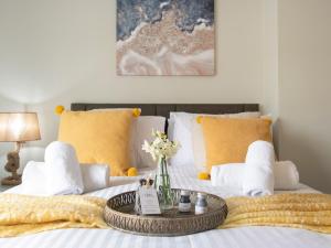 uma cama com almofadas amarelas e uma mesa sobre ela em Snowdrop Cottage em Seahouses