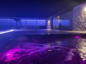 a swimming pool at night with purple lights at Hafan Dawel in Verwick