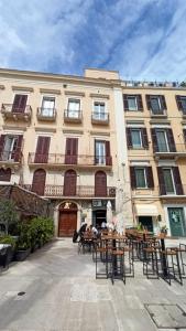 a building with tables and chairs in front of it at Just Here apartments - La mansarda in Bari