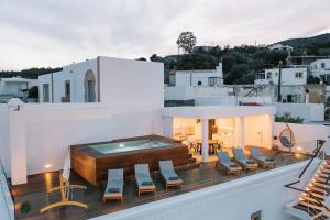 einen Balkon mit Stühlen und einen Pool auf einem Gebäude in der Unterkunft Kalathos Square luxury suites in Kalathos