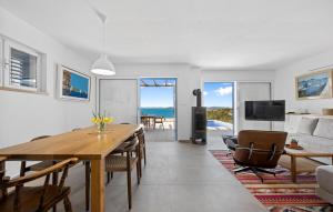 a living room with a table and a living room with the ocean at Stunning Home In Murter With House Sea View in Murter