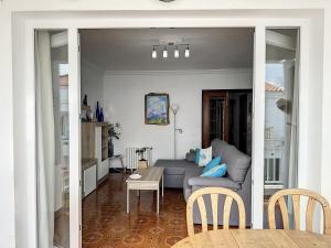 un soggiorno con un divano e un tavolo di Apartamento acogedor cerca del mar en Fornells a Fornells