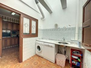 una cucina con lavatrice e lavandino di Apartamento acogedor cerca del mar en Fornells a Fornells