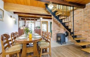 a dining room with a wooden table and a fireplace at Amazing Home In Podgorje Bistricko With Kitchen in Marija Bistrica