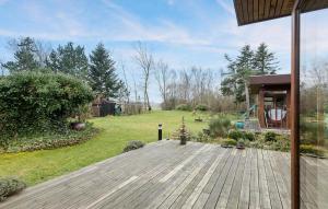 a backyard with a wooden deck and a yard at Lovely Home In Hundested With Wifi in Hundested