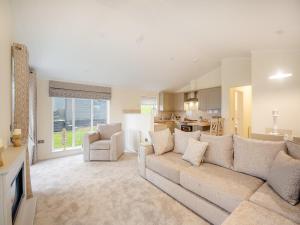 uma sala de estar com um sofá e uma cozinha em Oak View Lodge em Llanrhaiadr
