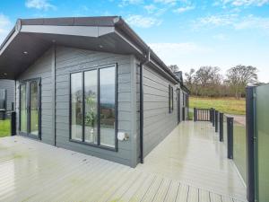 Casa modular con terraza y ventana grande en Oak View Lodge en Llanrhaiadr