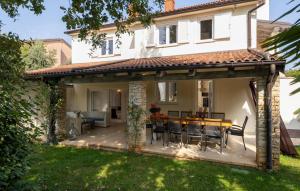 a patio with a table and chairs in front of a house at Villa Duga in Poreč +22 photos