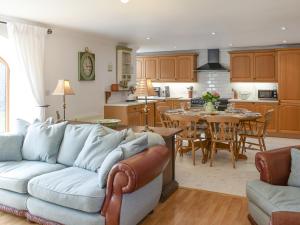 a living room and kitchen with a couch and a table at Mill Barn in Milfield