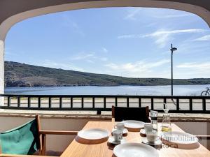 a table with chairs and a view of the water at Roca Fornells, Apartamento en Tramontana F239 in Fornells