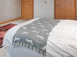 a bed with a blanket with horses on it at Park Barn in Whittington