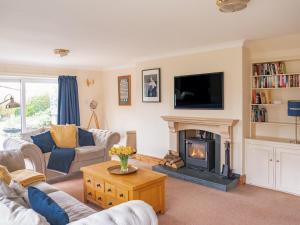 a living room with a fireplace and a tv at Cranny Hill in Walpole