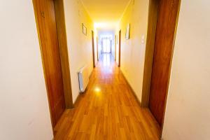 korytarz z drewnianą podłogą i korytarz prowadzący do drzwi w obiekcie Alejandro w mieście Junín de los Andes