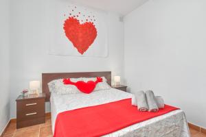 une chambre avec un lit avec un cœur rouge sur le mur dans l'établissement Apartamento Almijara 2, à Nerja 18 autres photos