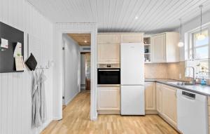 a kitchen with white appliances and wooden cabinets at 3 Bedroom Beautiful Home In Vordingborg in Vordingborg