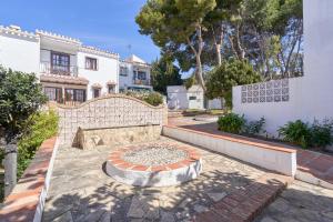 une cour avec une fontaine en pierre en face d'un bâtiment dans l'établissement Apartamento Almijara 2, à Nerja