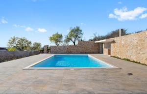 una piscina en un patio junto a una pared de ladrillo en Beautiful Home In Skradin With Kitchen, en Piramatovci