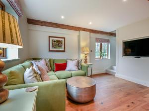 uma sala de estar com um sofá verde e uma mesa em Keeds Barn em Arundel