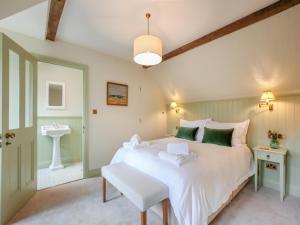 a bedroom with a large white bed and a sink at Keeds Barn in Arundel