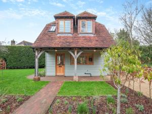 une petite maison blanche avec un toit rouge dans l'établissement Keeds Barn, à Arundel