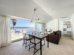 a dining room with a table and a couch at Roca Fornells, Atico Maritimo F05 in Fornells +29 photos
