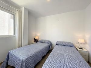 two beds in a room with a window at Roca Fornells, Atico Maritimo F05 in Fornells
