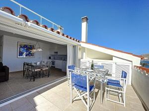 a balcony with a table and chairs on a patio at Roca Fornells, Atico Maritimo F05 in Fornells