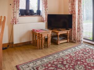 a living room with a flat screen tv and a table at Uk46717 - The Orchard in Plumstead