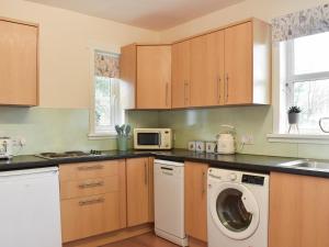 a kitchen with a washing machine and a microwave at Mains Of Asloun Two - Uk44788 in Alford