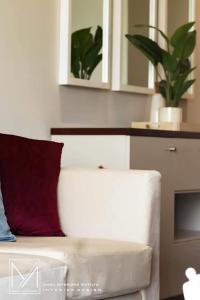 un divano bianco con cuscino rosso in soggiorno di Canterbury Golf Resort Apartments a Piliyandala