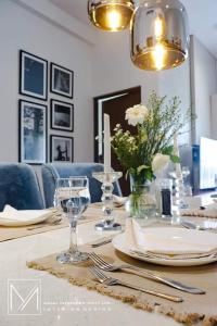 tavolo da pranzo con piatti e bicchieri da vino di Canterbury Golf Resort Apartments a Piliyandala