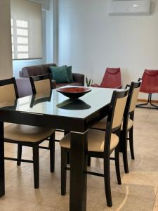 mesa de comedor negra con sillas y sofá en DEPARTAMENTO Céntrico MENDOZA en Mendoza