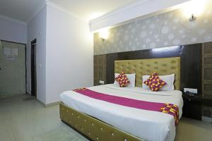 a bedroom with a large white bed with pillows at Airport KINGDOM in New Delhi