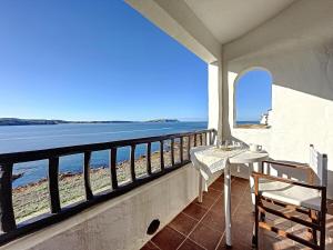 balcón con mesa, sillas y vistas al océano en P98 - Bonito apartamento sobre el mar en Fornells