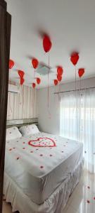 een slaapkamer met rode ballonnen aan het plafond bij Suíte em Cobertura, Não é a cobertura toda, somente suíte e piscina in Bombinhas