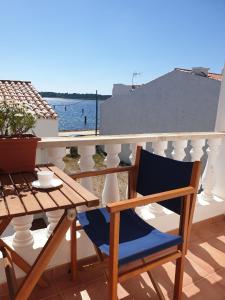 einem blauen Stuhl auf einem Balkon mit einem Tisch in der Unterkunft F105 · Dos dormitorios, terraza y a/c en Fornells in Fornells