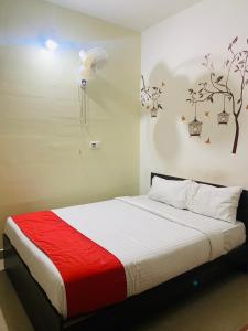 a bedroom with a bed with a red and white blanket at Western Silicon Hotel in Bengaluru +42 photos