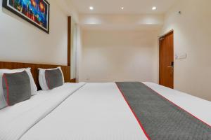 a bedroom with a large white bed with pillows at Super Townhouse 1144 Hotel RCC 7 Lamps in Alipur