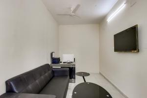 uma sala de estar com um sofá e uma televisão de ecrã plano em Capital O New Paradise Inn em Irugūr