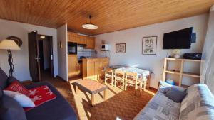 a living room with a couch and a table and a kitchen at Eperon 2 - F4 - Studio lumineux - 6 pers in Les Deux Alpes