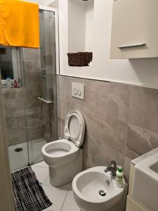 uma casa de banho com um WC, um lavatório e um chuveiro em Romantic Chic Loä em Loano