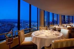 un restaurante con mesas y sillas y vistas en The Westin Bonaventure Hotel & Suites, Los Angeles en Los Ángeles
