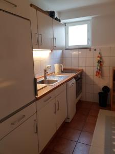 a kitchen with white cabinets and a sink and a window at Ferienwohnung 'dasBRENNERs' in Groß-Umstadt