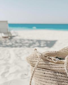 una bolsa de paja sentada en una playa con el océano en Le Sidi Cabanas Hacienda Bay en El Alamein