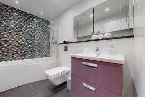 a bathroom with a sink and a toilet and a tub at Beautiful 2Bed Apartment with lift in Kensington in London