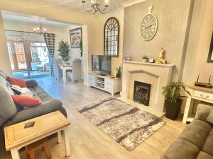 a living room with a couch and a fireplace at Sea View Three Bed Detached Home - With Parking - Next to Beach! in Bournemouth