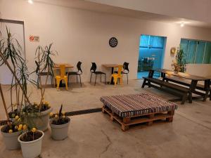 a living room with tables and chairs and a bench at Suítes Stettin in Pomerode